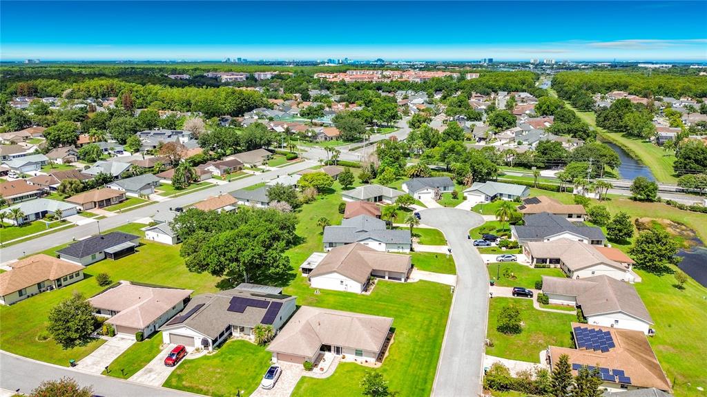 An aerial view shows a suburban neighborhood with single-story houses, green lawns, and paved streets — 5518 SANDY HILL DRIVE, ORLANDO, FL