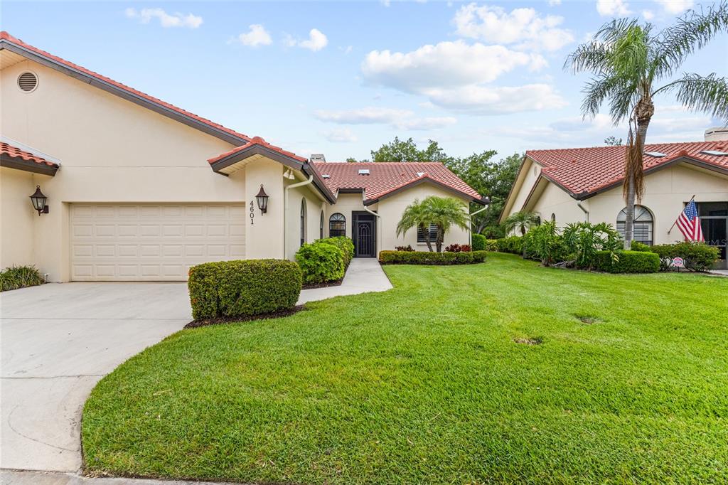 A single-story house with a tile roof, beige stucco exterior, and a two-car garage — 4601 LAS BRISAS LANE, SARASOTA, FL
