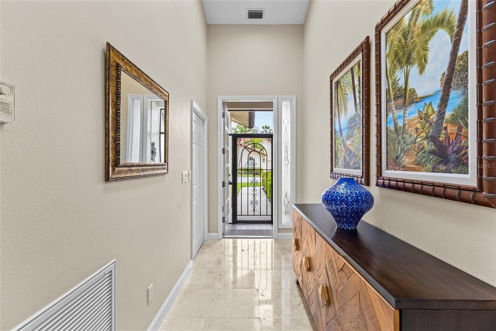 A bright entryway features a tile floor, a wooden console table, and a front door — 4601 LAS BRISAS LANE, SARASOTA, FL