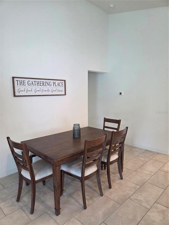 A dining area features a wooden table with four chairs and a wall sign — 4570 PENKERT PLACE, LAKELAND, FL