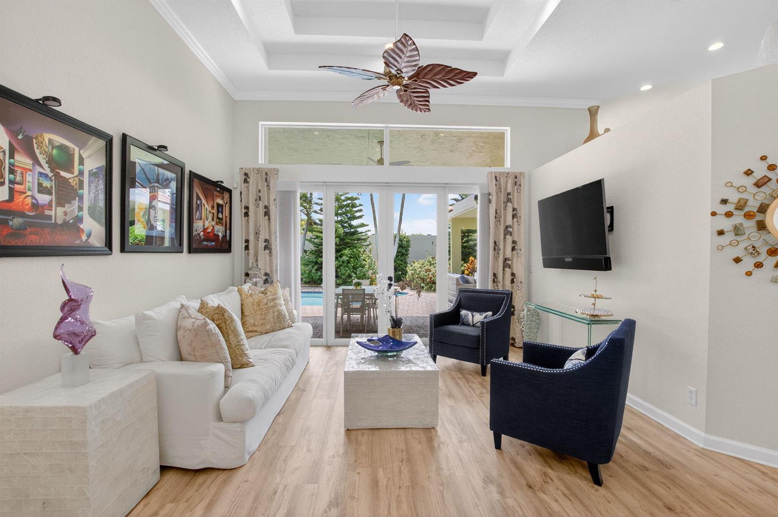 A living room with a white sofa, two navy armchairs, and glass doors to a patio — 12657 Oak Run Court, Boynton Beach FL 33436, BOYNTON BEACH, FL
