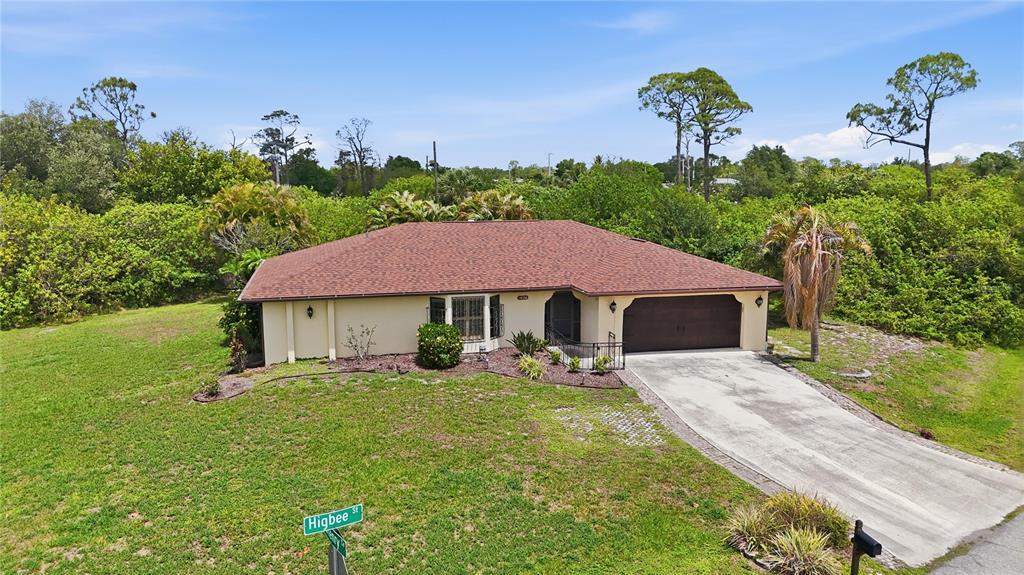 An aerial view of a single-story house with a brown roof and a concrete driveway — 19358 ABHENRY CIRCLE, PORT CHARLOTTE, FL
