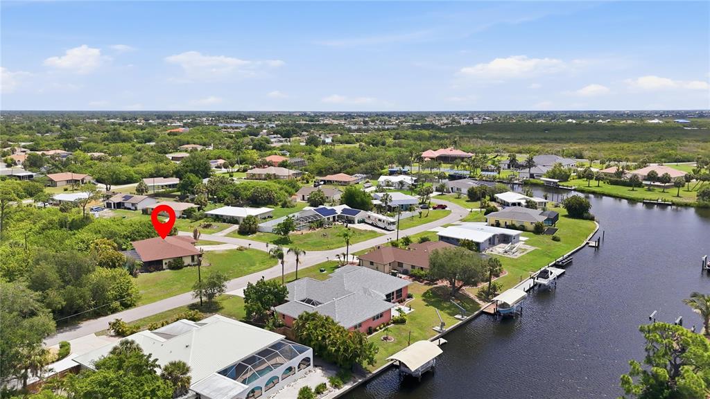An aerial view shows a residential neighborhood with houses, a canal, and a red location marker — 19358 ABHENRY CIRCLE, PORT CHARLOTTE, FL