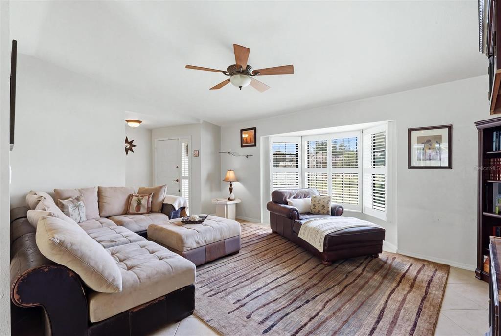 A living room features a large sectional sofa, a chaise lounge, and a striped area rug — 19358 ABHENRY CIRCLE, PORT CHARLOTTE, FL