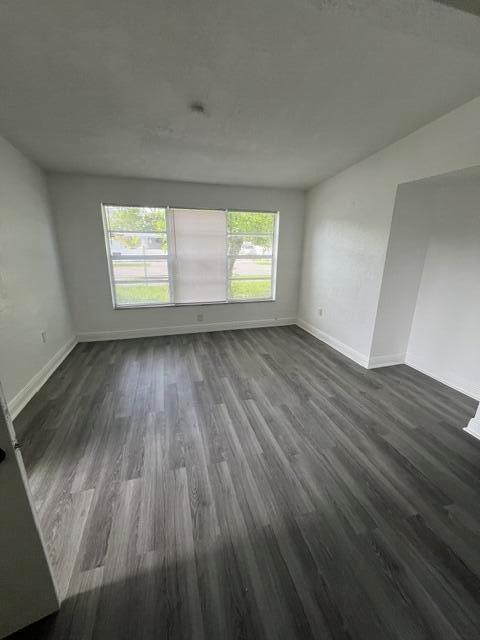An empty room features gray wood-look flooring, white walls, and a large window with blinds — 3150 NW 3rd Street, Lauderhill FL 33311, LAUDERHILL, FL