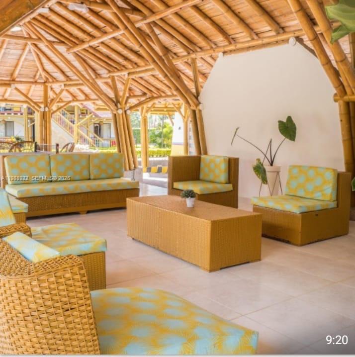 An open-air patio features wicker furniture with patterned cushions under a bamboo-framed roof — Outside of Country, NO, NO