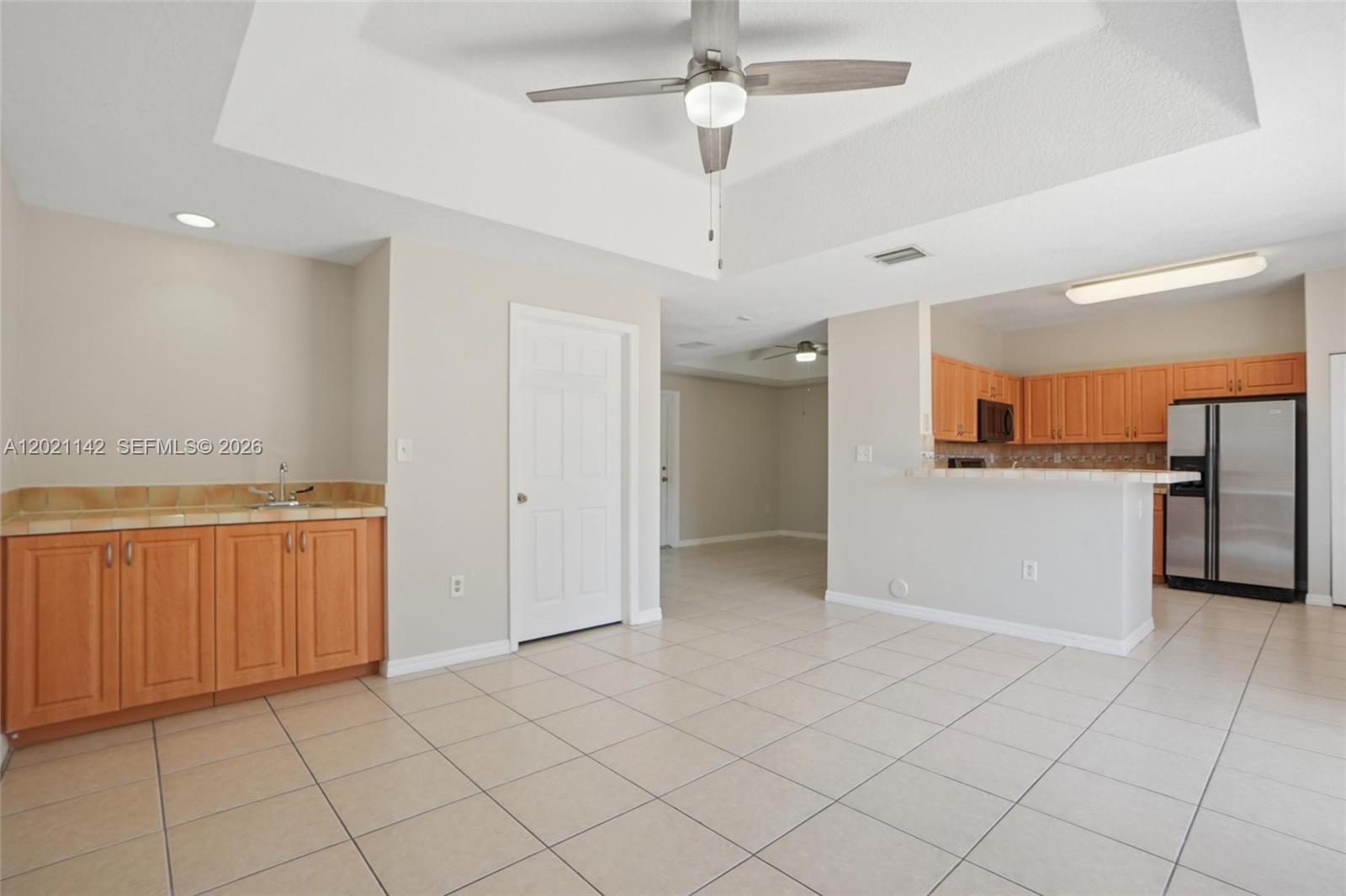 A room with tile flooring, a ceiling fan, a wet bar, and an adjacent kitchen — 8351 SW 124th Ave # 106, Miami FL 33183, MIAMI, FL