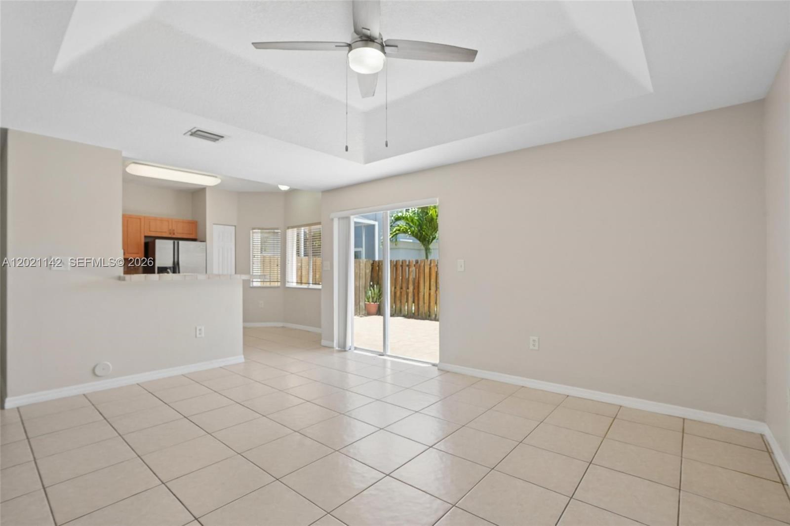 A living room with tile flooring, a tray ceiling, and a sliding glass door — 8351 SW 124th Ave # 106, Miami FL 33183, MIAMI, FL