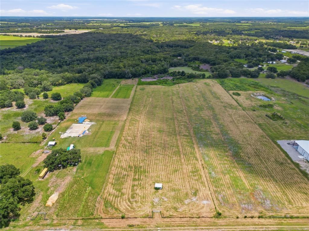 An aerial view shows a large, rectangular field of mowed grass with a small shed — S US HWY 17, ZOLFO SPRINGS, FL
