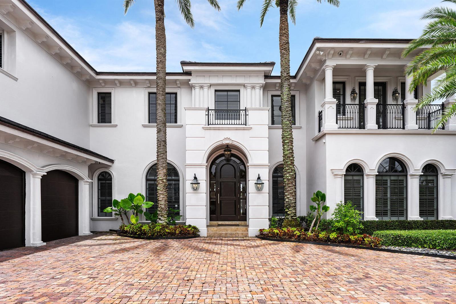 The exterior of a two-story white house features a brick driveway and two palm trees — 450 S Maya Palm Drive, Boca Raton FL 33432, BOCA RATON, FL
