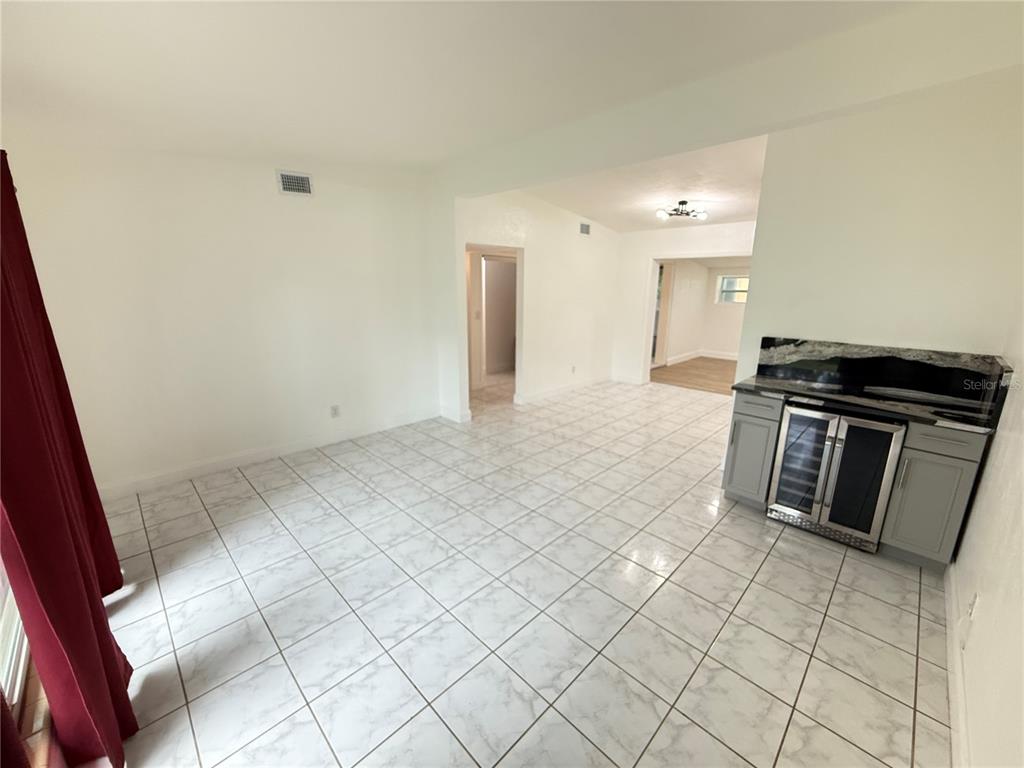 A room with white tile flooring, a small wet bar, and an open doorway — 4394 POMPANO DRIVE SE, ST PETERSBURG, FL