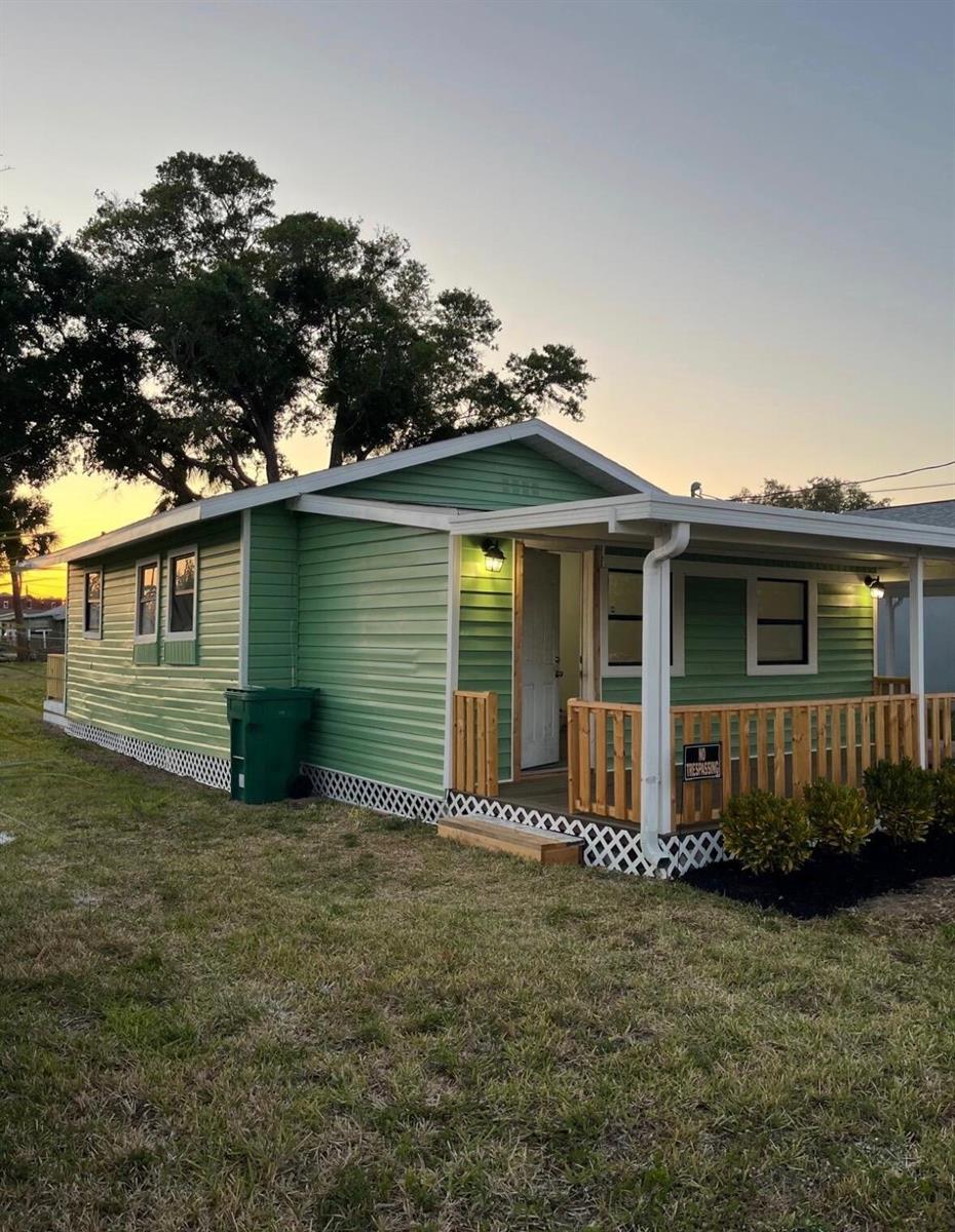 A green single-story house with a wooden porch, white trim, and lattice skirting — 515 S Wilson Avenue, Cocoa FL 32922, COCOA, FL