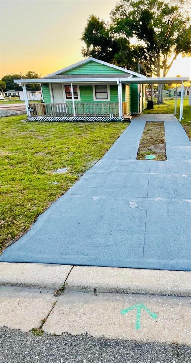 A green house with a front porch and a concrete driveway with a grass strip — 515 S Wilson Avenue, Cocoa FL 32922, COCOA, FL