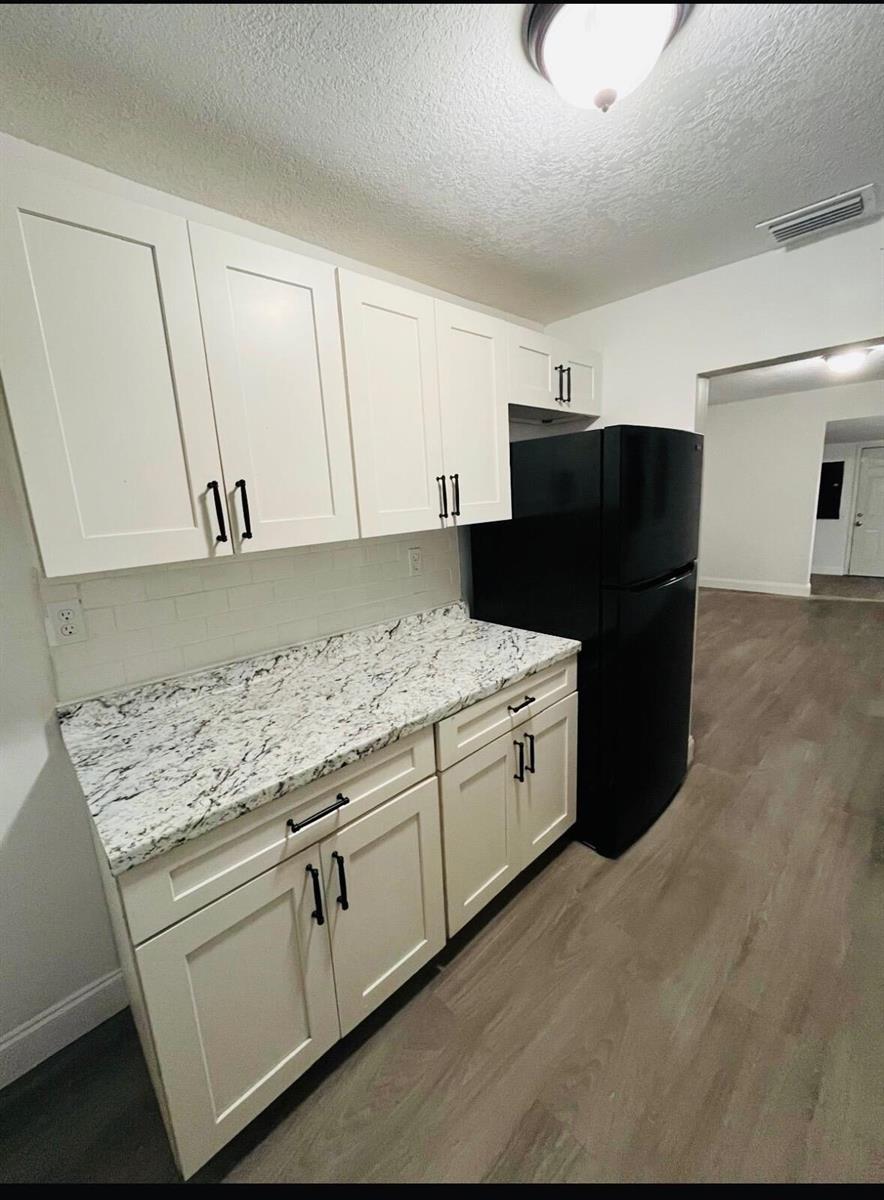 A kitchen features white shaker cabinets, granite countertops, a white subway tile backsplash, and black appliances — 515 S Wilson Avenue, Cocoa FL 32922, COCOA, FL