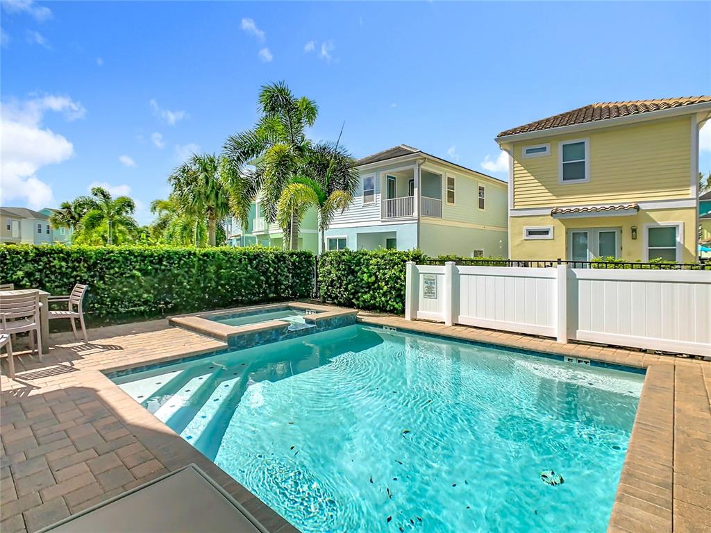 A backyard swimming pool and hot tub are enclosed by a white vinyl fence — 2946 SALTED RIM ROAD, KISSIMMEE, FL
