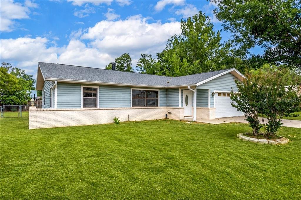 A single-story house with light blue siding, a white brick base, and an attached garage — 4515 SE 59TH STREET, OCALA, FL
