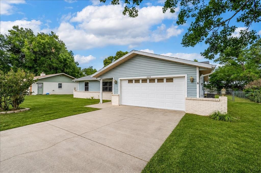 A light blue single-story house with a white garage door and a concrete driveway — 4515 SE 59TH STREET, OCALA, FL