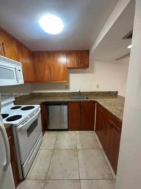 A kitchen features wood cabinets, a white stove, a stainless steel dishwasher, and tile flooring — 14250 SW 62nd St # 221, Miami FL 33183, MIAMI, FL