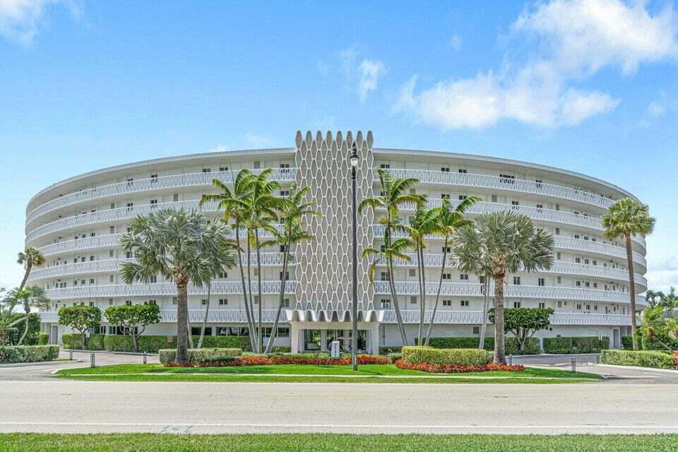 A multi-story, curved residential building features a central decorative screen and surrounding palm trees — 2505 S Ocean Boulevard # 303, Palm Beach FL 33480, PALM BEACH, FL