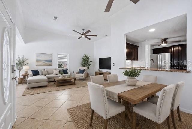 An open-concept living and dining area features tile flooring, vaulted ceilings, and a kitchen pass-through — 1649 8TH STREET, SARASOTA, FL