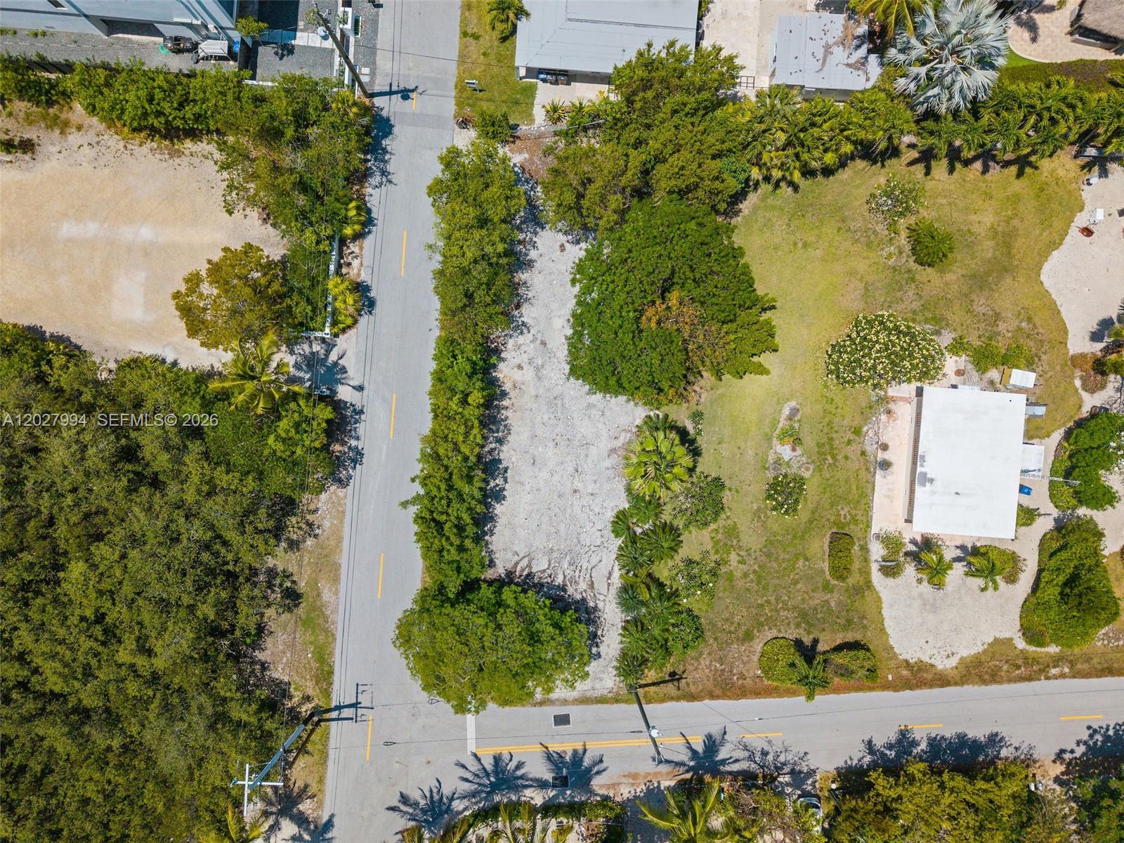 An aerial view shows a vacant, rectangular lot bordered by trees and paved roads — 0 Seaside Ave, Key Largo FL 33037, KEY LARGO, FL