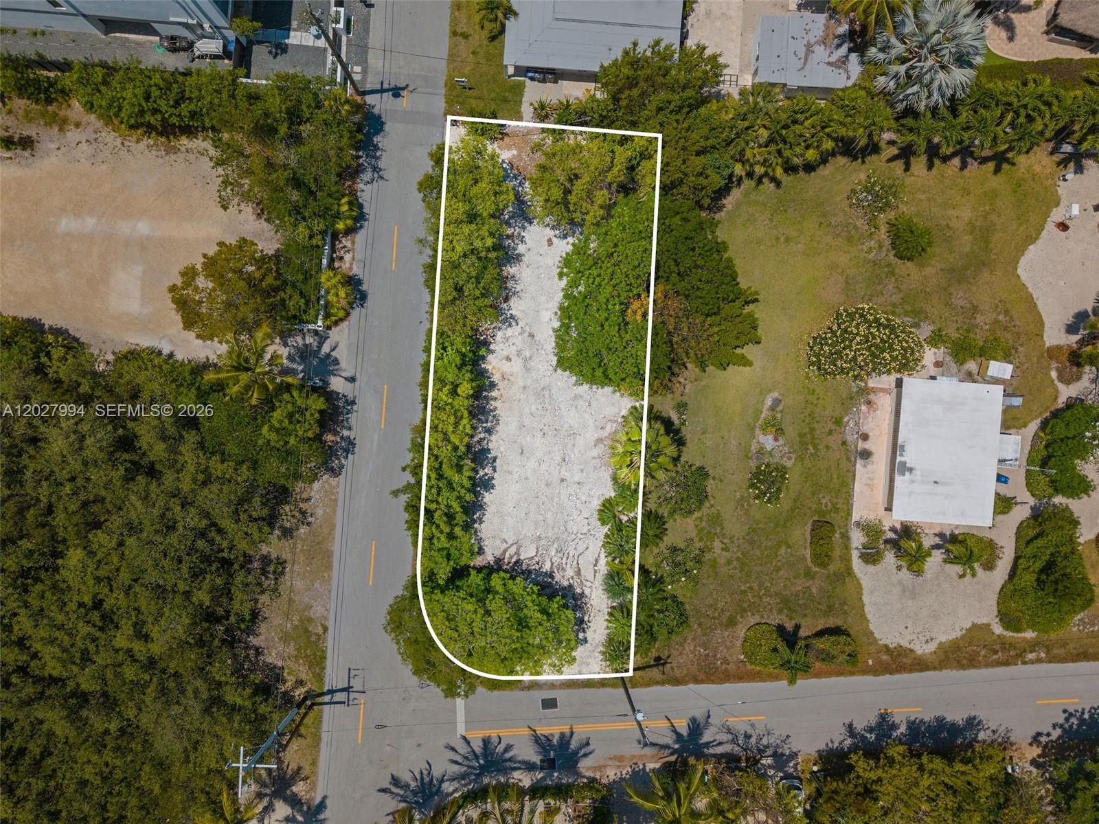An aerial view shows a vacant, rectangular lot outlined in white between two paved roads — 0 Seaside Ave, Key Largo FL 33037, KEY LARGO, FL