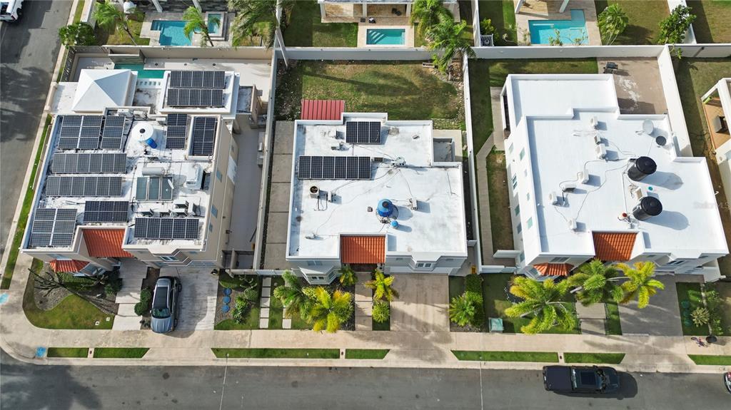 An aerial view shows three residential houses with swimming pools and solar panels on their roofs — L2 MAR MEDITERRANEO STREET, DORADO, PR
