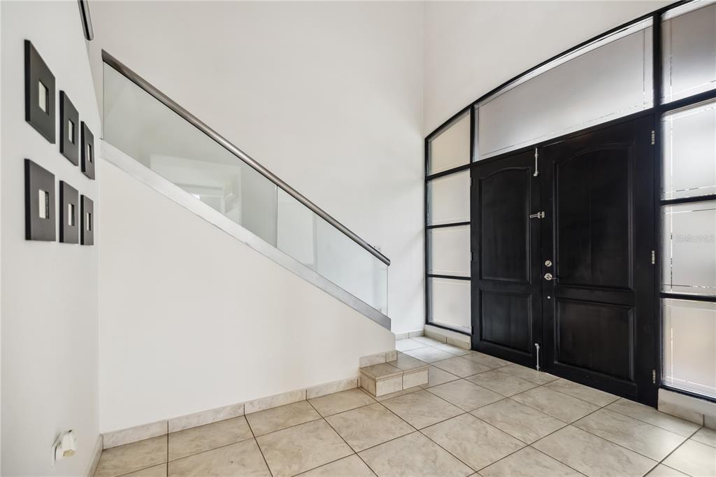 An entryway features a tiled floor, a glass-railed staircase, and a large black double door — L2 MAR MEDITERRANEO STREET, DORADO, PR