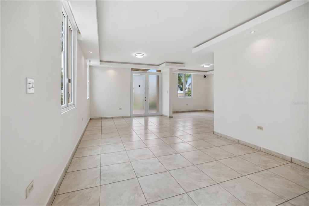 An empty room with white walls, tiled floors, recessed lighting, and glass double doors — L2 MAR MEDITERRANEO STREET, DORADO, PR