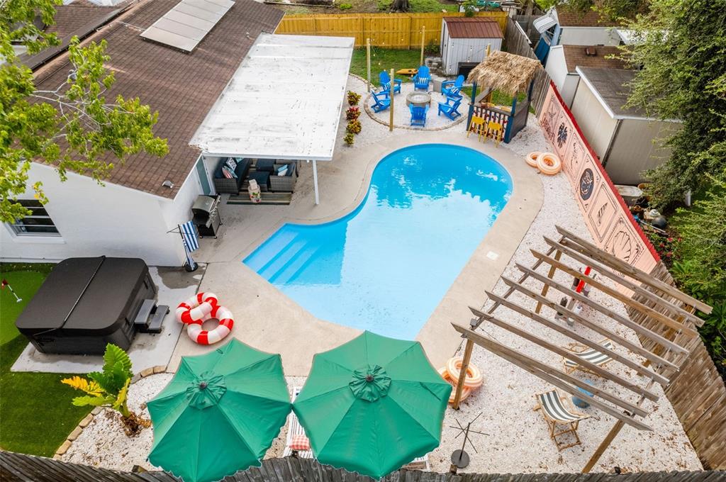 An aerial view of a backyard featuring a swimming pool, hot tub, and patio area — 7957 COTTONWOODE DRIVE, LARGO, FL