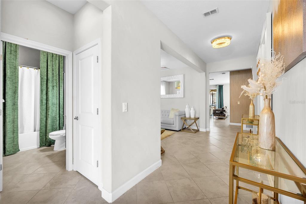 A tiled hallway leads past a bathroom with green curtains toward a living area — 13344 ORCA SOUND DRIVE, RIVERVIEW, FL