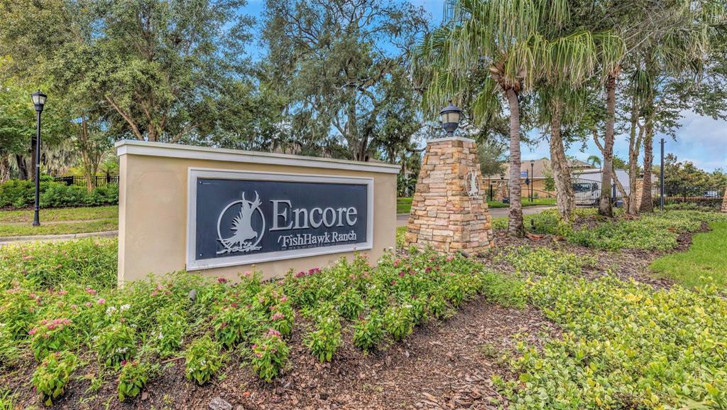 A stone-based monument sign for Encore at FishHawk Ranch stands amidst landscaping and mature trees — 13931 NATURES RESERVE DRIVE, LITHIA, FL