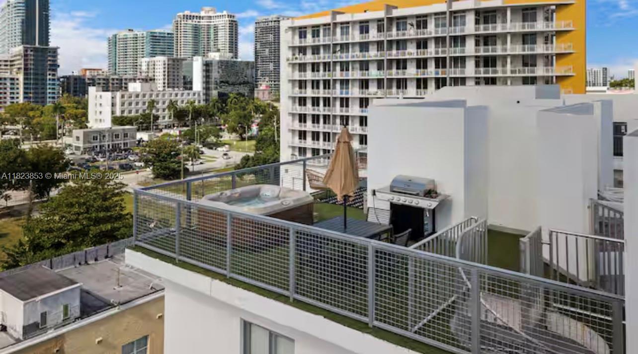 A rooftop terrace features a hot tub, a grill, and a dining area with an umbrella — 481 NE 29th St # 706, Miami FL 33137, MIAMI, FL