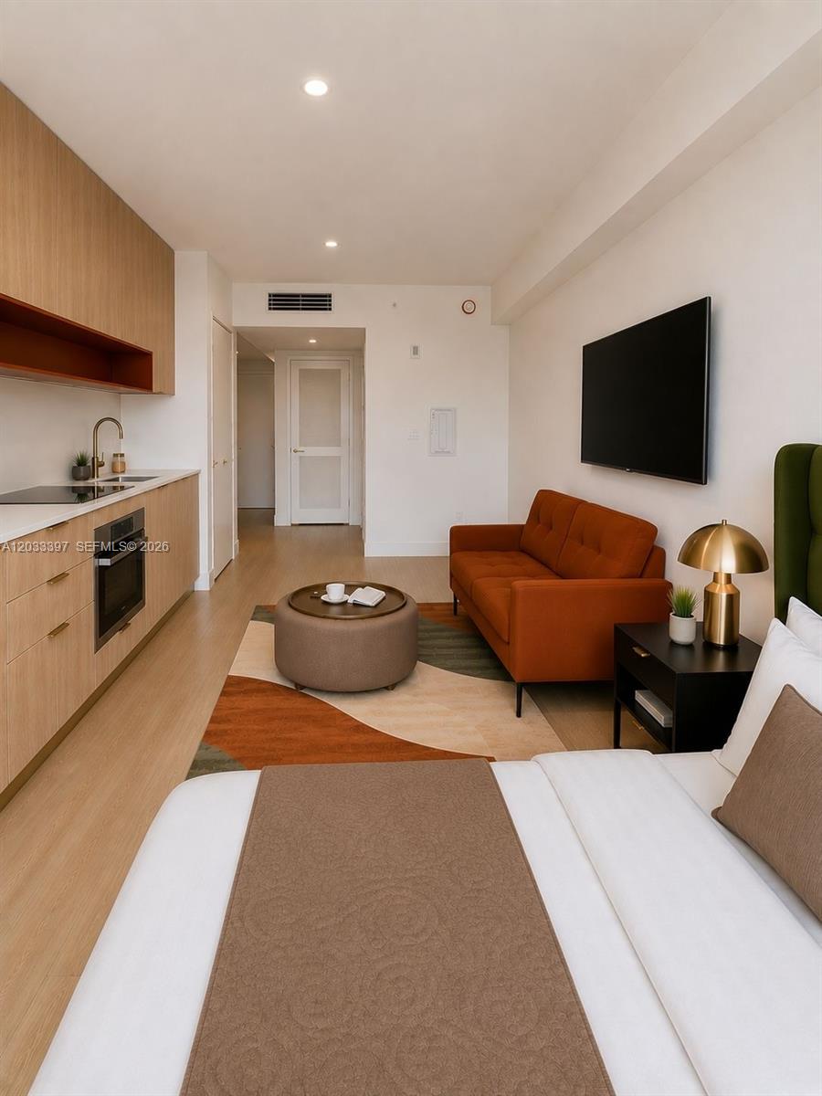A studio apartment features a kitchenette, a sofa, and a bed in one open space — 90 NE 32ND ST # 923, Miami FL 33137, MIAMI, FL