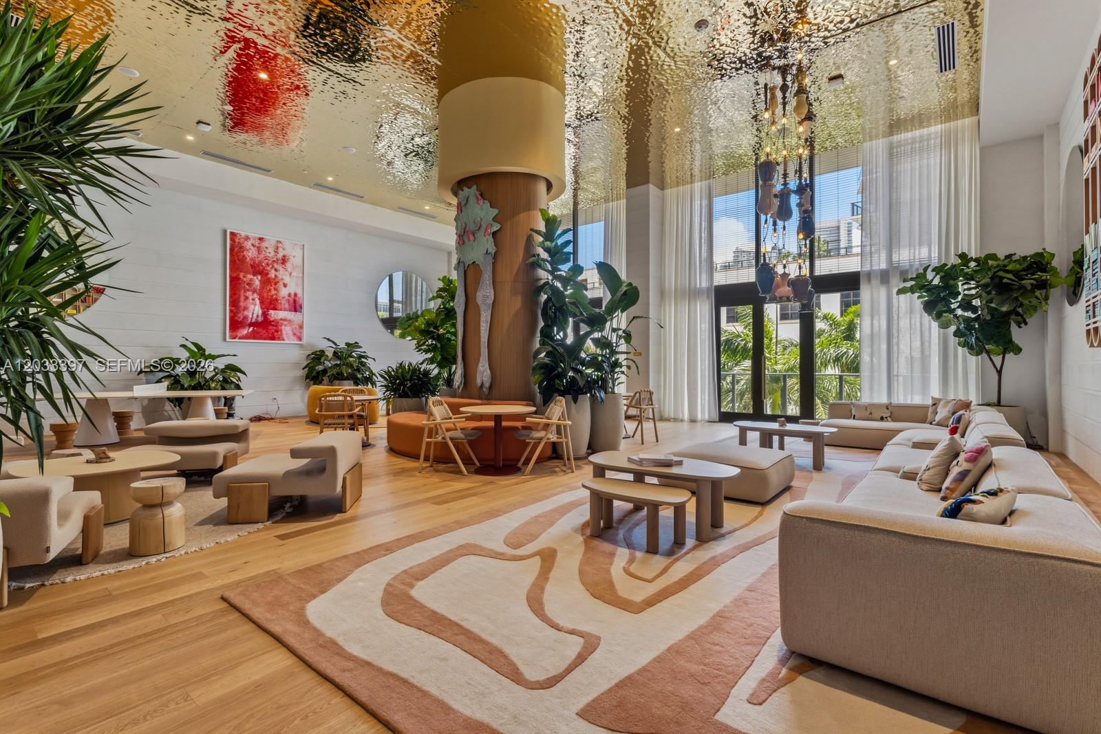 A spacious, modern lounge with a metallic ceiling, large central column, and contemporary seating areas — 90 NE 32ND ST # 923, Miami FL 33137, MIAMI, FL