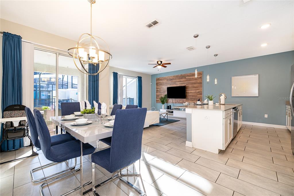 A two-story townhouse exterior with gray stucco walls, multiple windows, and two covered entryways — 4982 WINDERMERE AVENUE, KISSIMMEE, FL