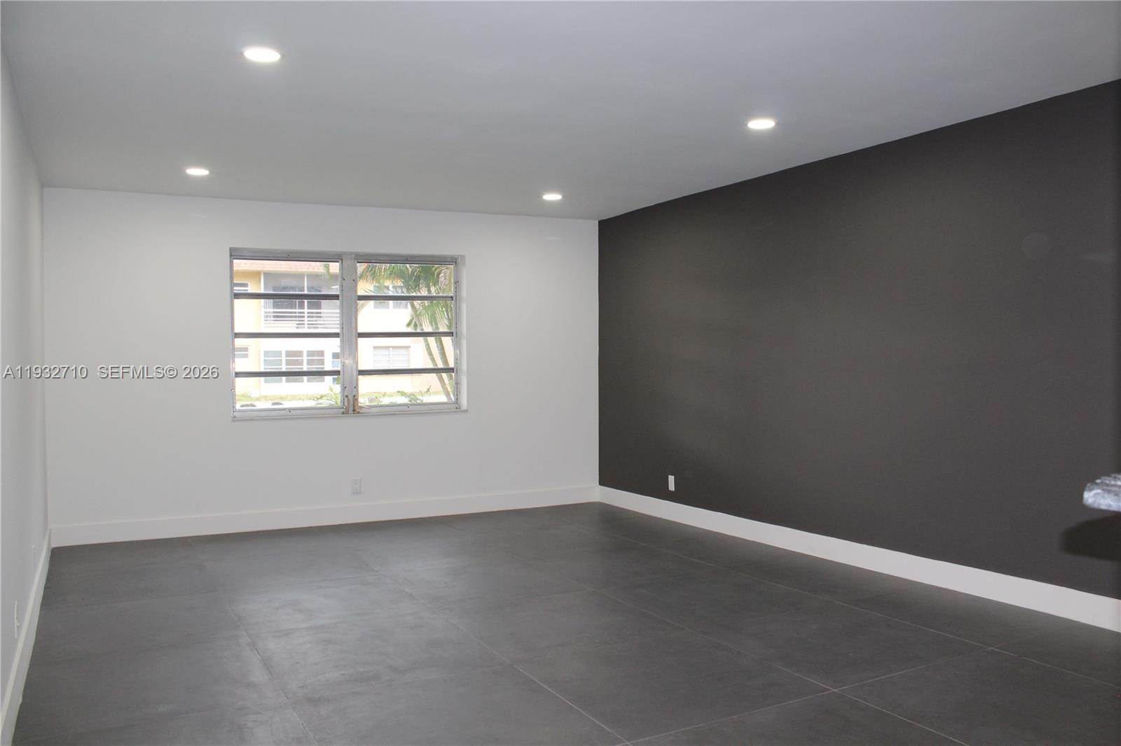 A room with gray tile flooring, white walls, and a dark gray accent wall — 5140 SW 40th Ave # 3C, Dania Beach FL 33314, DANIA BEACH, FL