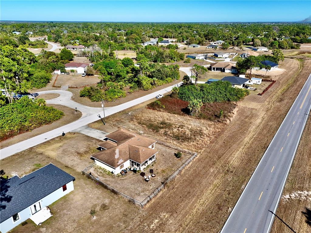 An aerial view shows a house with a brown roof situated between two paved roads — 3019 S BALSAM CIRCLE, LABELLE, FL