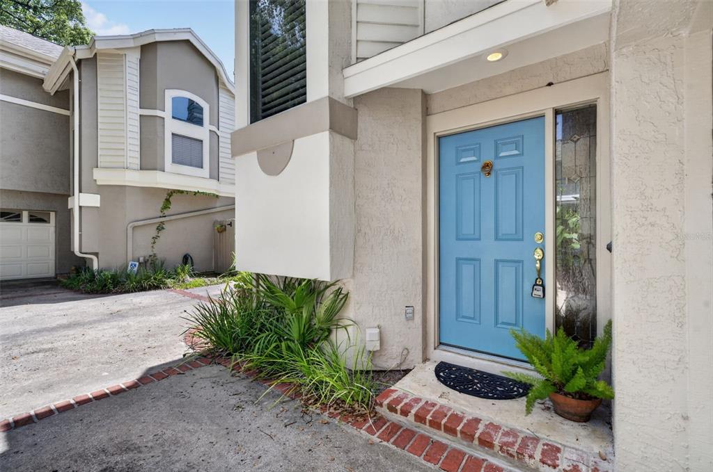 A light blue front door with a brass knocker sits beside a small potted fern — 786 MCINTYRE AVENUE, WINTER PARK, FL