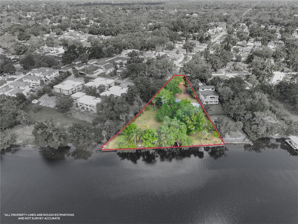 An aerial view shows a triangular waterfront lot outlined in red with trees and structures — 6605 N BOULEVARD, TAMPA, FL