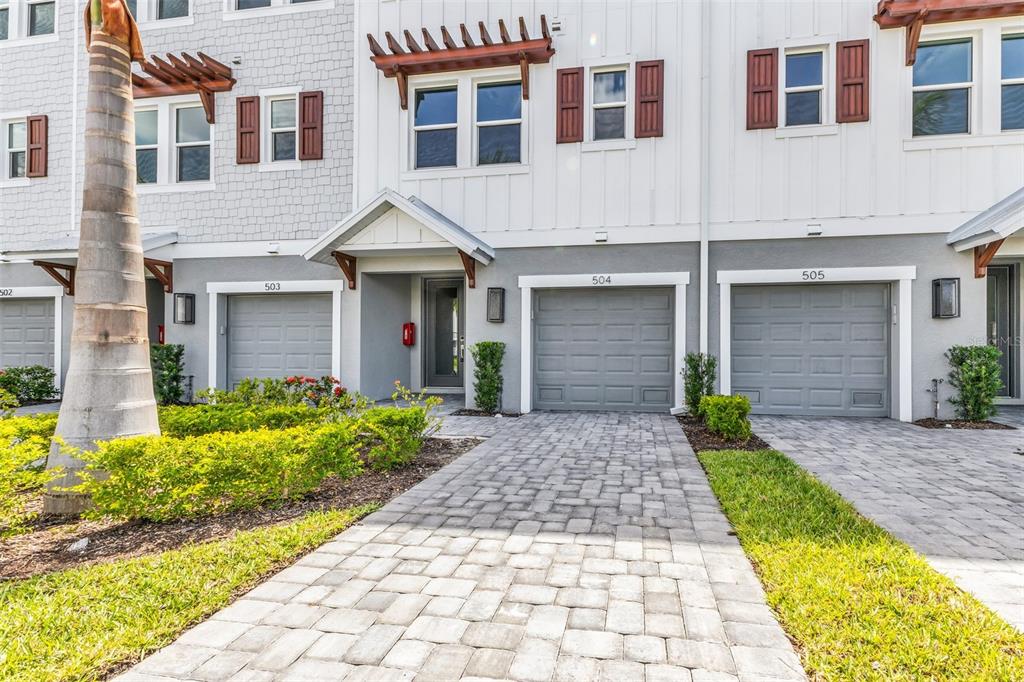 The exterior of a multi-unit townhouse complex features gray garage doors and paved driveways — 1617 SEAHAVEN DRIVE UNIT 504, PUNTA GORDA, FL