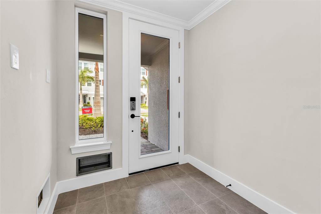 An entryway features a white door with a glass panel, a side window, and tile flooring — 1617 SEAHAVEN DRIVE UNIT 504, PUNTA GORDA, FL