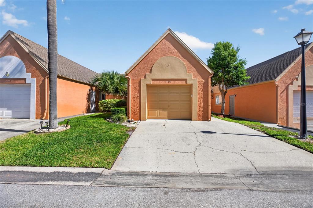 A single-story house with an orange stucco exterior and a tan garage door — 14617 LORIDAWN DRIVE UNIT 8, SEMINOLE, FL