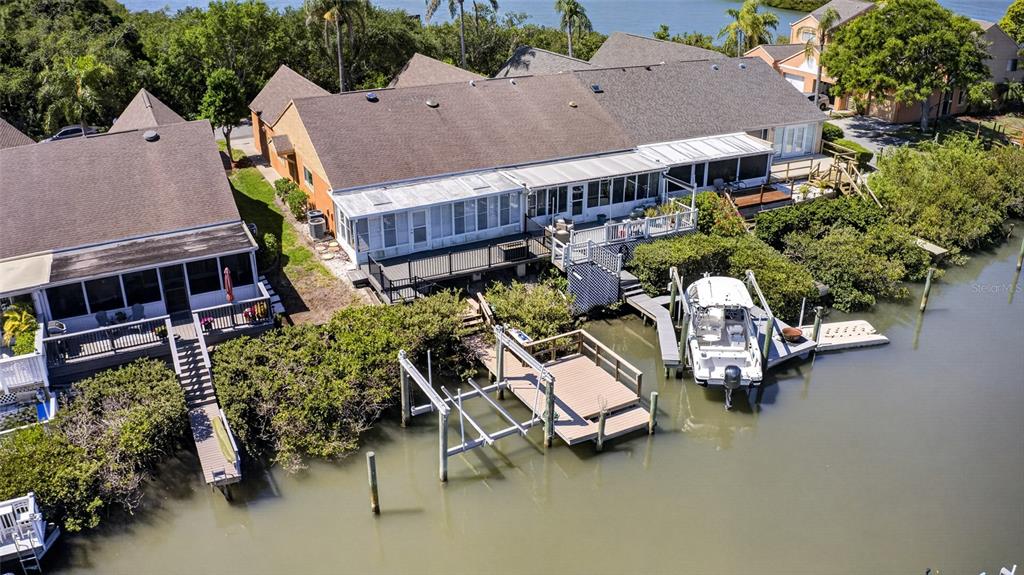 An aerial view of waterfront townhomes featuring private docks, boat lifts, and screened-in back porches — 14617 LORIDAWN DRIVE UNIT 8, SEMINOLE, FL