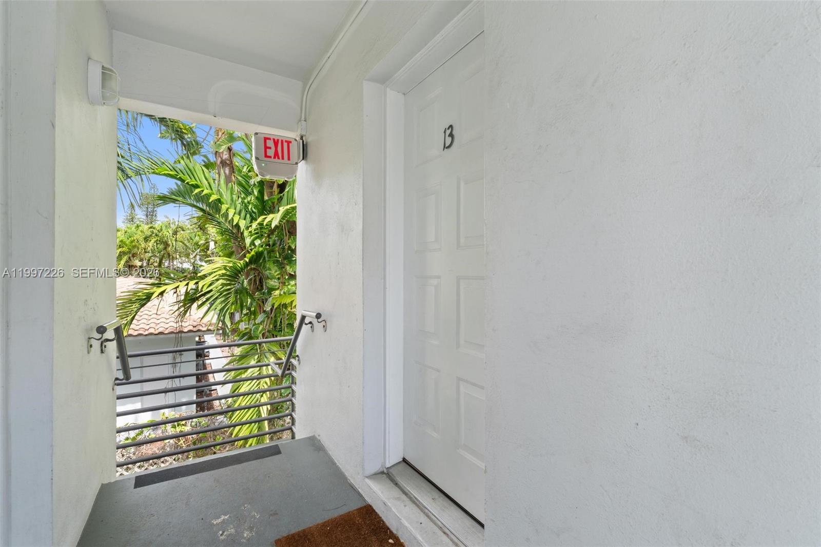 A white door labeled 13 opens onto an outdoor walkway with a metal railing — 541 NE 62nd St # 13, Miami FL 33138, MIAMI, FL