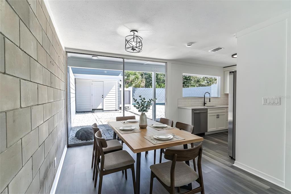 A dining area with a wooden table, gray chairs, and a sliding door to a patio — 1558 DREXEL AVENUE NE, WINTER HAVEN, FL