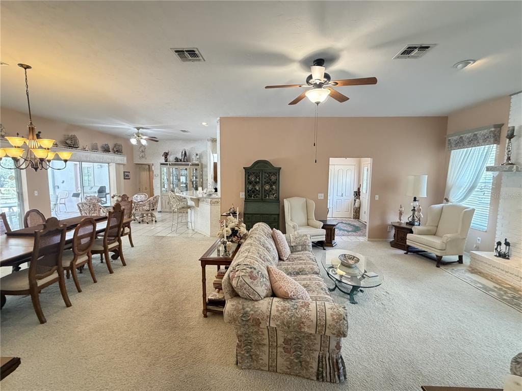 A living and dining area features carpeted floors, a floral sofa, and a ceiling fan — 20620 SW 97TH PLACE, DUNNELLON, FL
