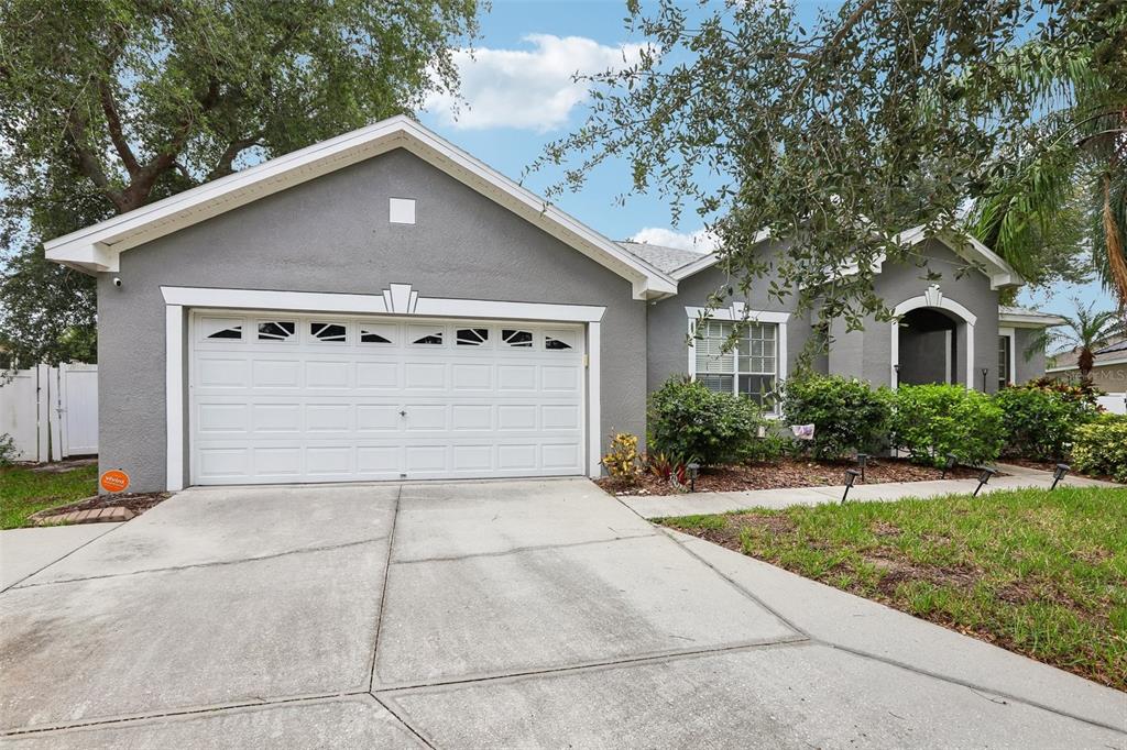 A gray single-story house with a two-car garage and a concrete driveway — 12517 SAFARI LANE, RIVERVIEW, FL