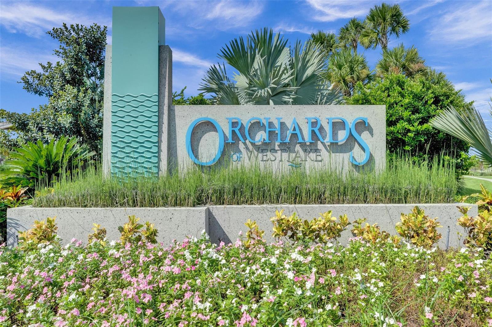 A concrete sign for Orchards of Westlake stands behind a bed of pink flowers — 5416 Macoon Way, FL 33470, FL