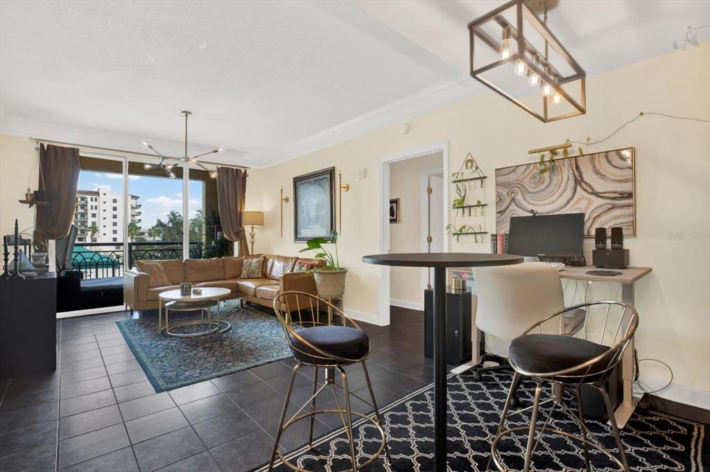 A living and dining area with dark tile floors, neutral furniture, and a balcony view — 345 BAYSHORE BOULEVARD UNIT 310, TAMPA, FL